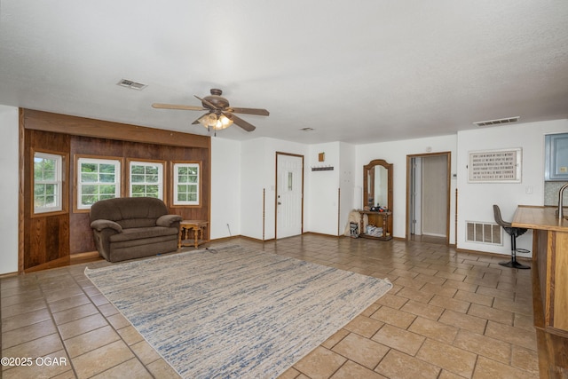 645 Worth St, Granby, MO 64844 - living room featuring ceiling fan and wood walls