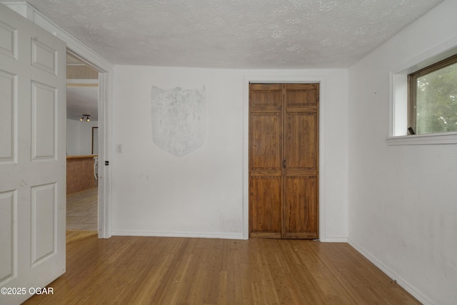 645 Worth St, Granby, MO 64844 - unfurnished bedroom with a textured ceiling, wood finished floors, and a closet