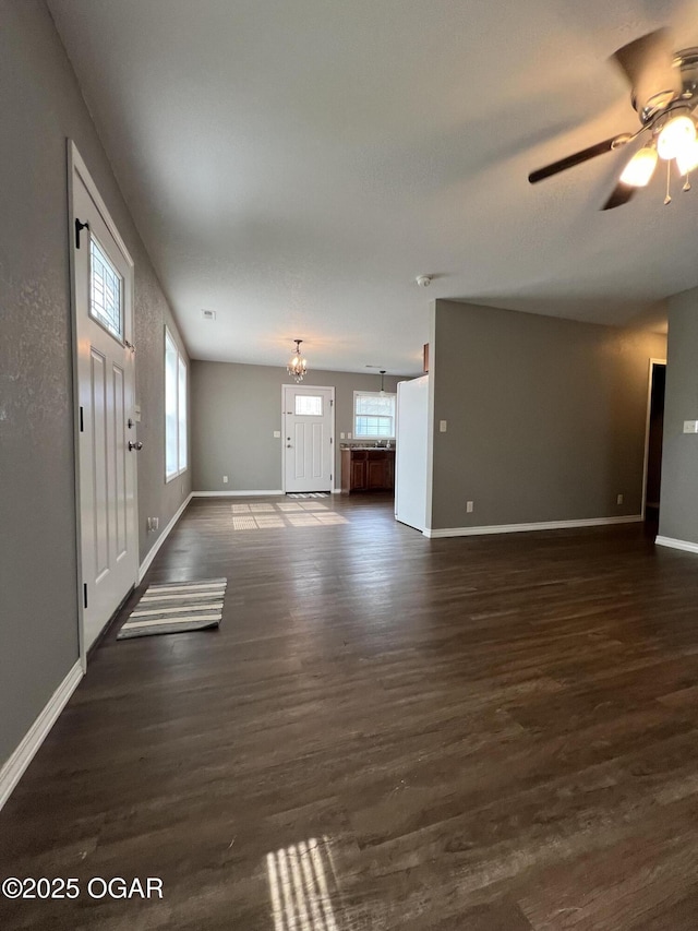 2124 S Byers Ave, Joplin, MO 64804 - unfurnished living room with plenty of natural light, a ceiling fan, dark wood-style flooring, and a chandelier