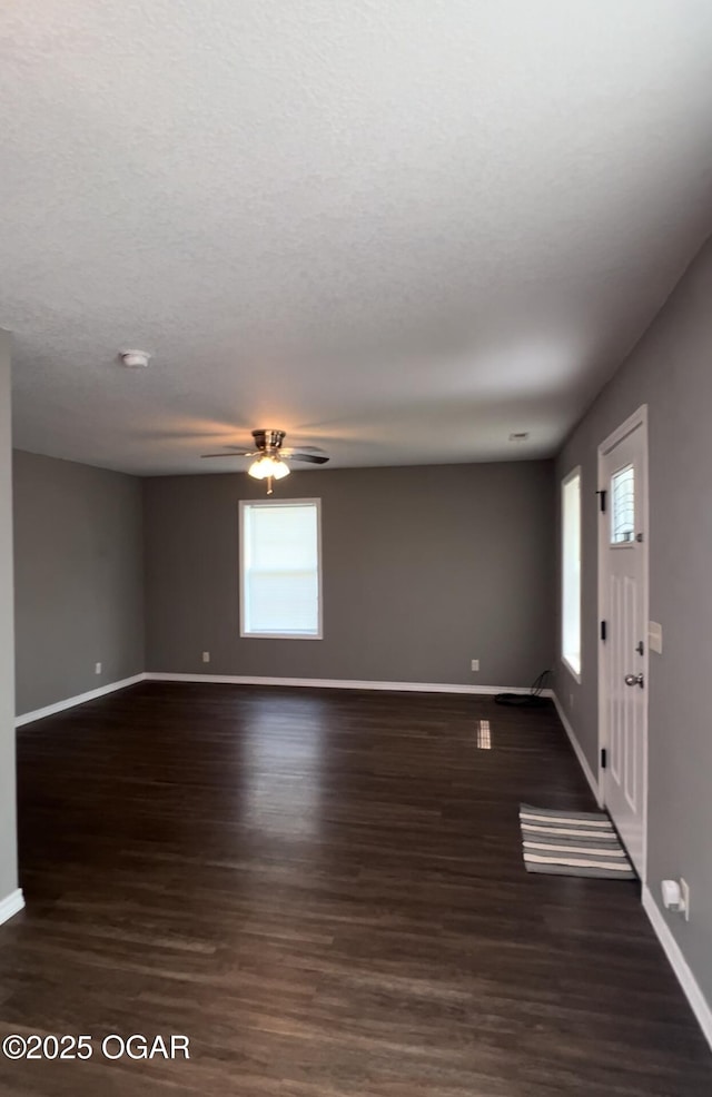 2124 S Byers Ave, Joplin, MO 64804 - empty room featuring healthy amount of natural light, ceiling fan, dark wood-type flooring, and a textured ceiling