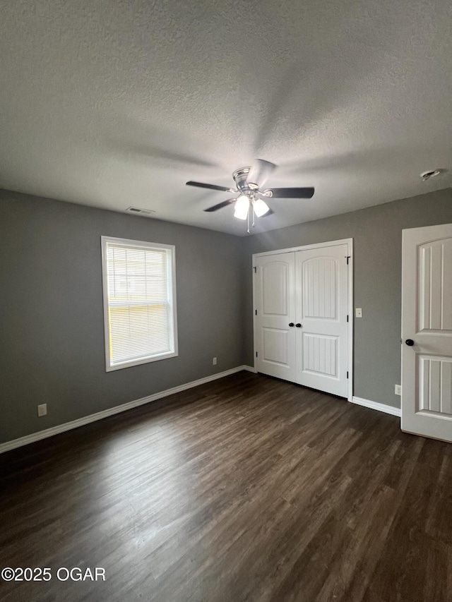 2124 S Byers Ave, Joplin, MO 64804 - unfurnished bedroom with dark wood-type flooring, a textured ceiling, a ceiling fan, and a closet