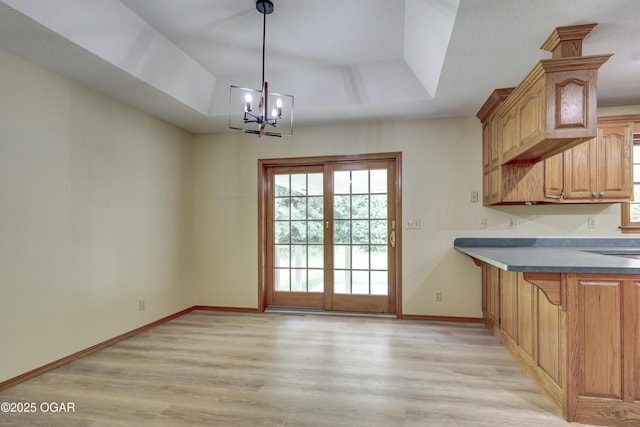 6181 County Lane 306, Carl Junction, MO 64834 - unfurnished dining area with light wood-type flooring, a chandelier, and a raised ceiling