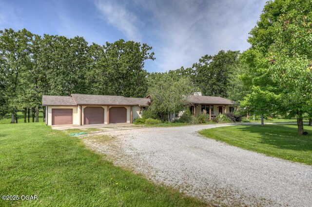 10640 Durango Ln, Carthage, MO 64836 - view of front of property with gravel driveway, a front lawn, and a garage