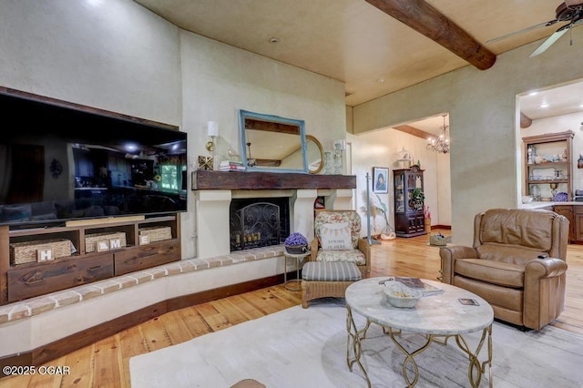 10640 Durango Ln, Carthage, MO 64836 - living room featuring hardwood / wood-style flooring, a brick fireplace, beamed ceiling, ceiling fan, and a chandelier