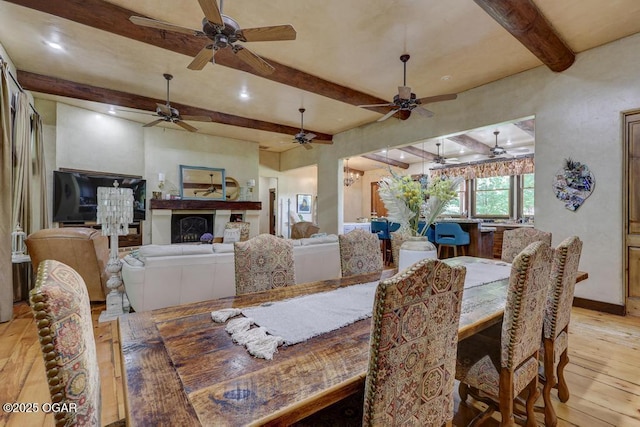 10640 Durango Ln, Carthage, MO 64836 - dining space with beamed ceiling, light wood finished floors, ceiling fan, and a fireplace