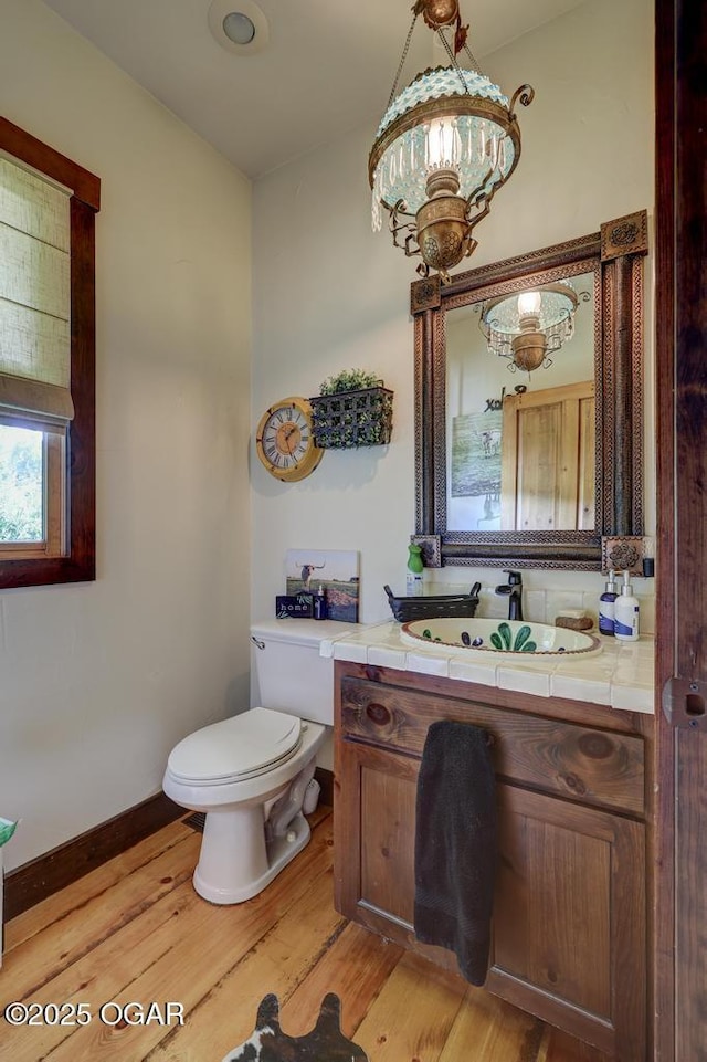 10640 Durango Ln, Carthage, MO 64836 - half bath featuring a chandelier, wood finished floors, and vanity