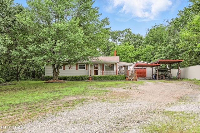 2015 W Zora St, Joplin, MO 64801 - view of front facade with dirt driveway, a chimney, a carport, and covered porch