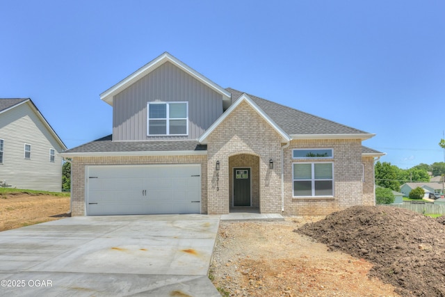 4313 W 28th Pl, Joplin, MO 64804 - view of front of property featuring board and batten siding, brick siding, driveway, a garage, and roof with shingles