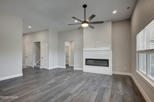 4313 W 28th Pl, Joplin, MO 64804 - unfurnished living room featuring a glass covered fireplace, ceiling fan, dark wood-style flooring, stairs, and recessed lighting