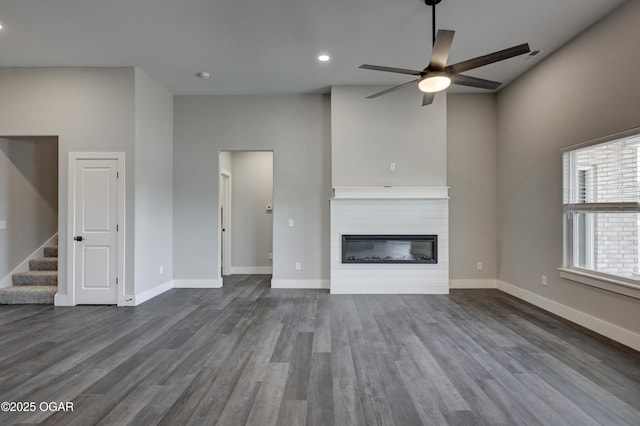 4313 W 28th Pl, Joplin, MO 64804 - unfurnished living room with ceiling fan, a glass covered fireplace, stairway, dark wood finished floors, and recessed lighting