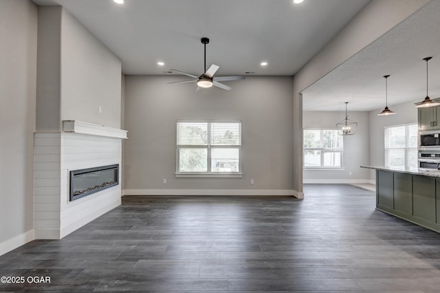 4313 W 28th Pl, Joplin, MO 64804 - unfurnished living room with a ceiling fan, a glass covered fireplace, recessed lighting, and dark wood-style flooring