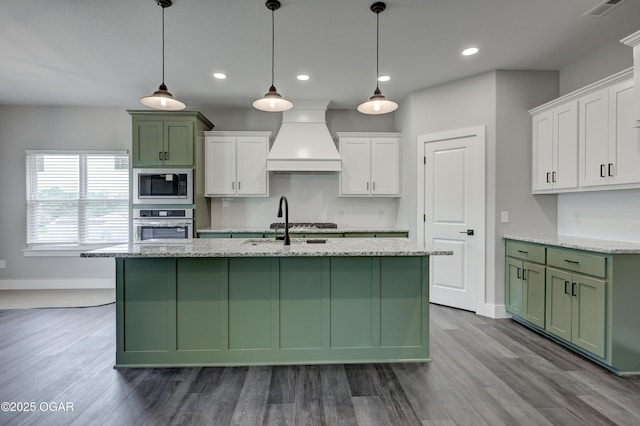 4313 W 28th Pl, Joplin, MO 64804 - kitchen with stainless steel appliances, premium range hood, green cabinets, an island with sink, and recessed lighting