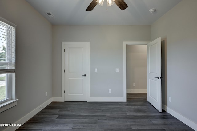 4313 W 28th Pl, Joplin, MO 64804 - unfurnished bedroom with multiple windows, dark wood-style flooring, and ceiling fan
