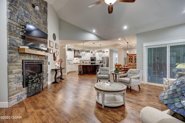 6133 Ridgeview Ct, Joplin, MO 64804 - living area featuring a fireplace, ceiling fan, wood-type flooring, and high vaulted ceiling