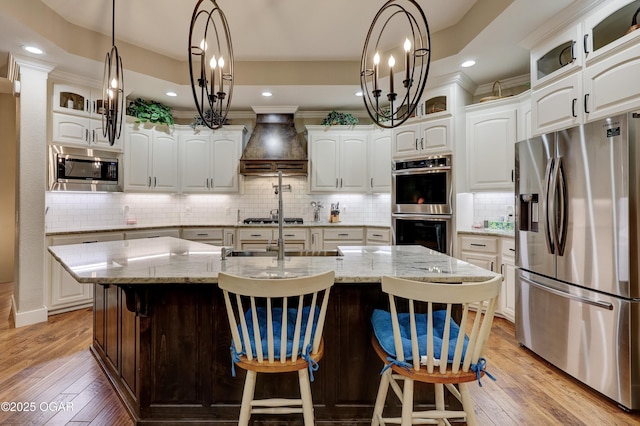 6133 Ridgeview Ct, Joplin, MO 64804 - kitchen featuring stainless steel appliances, custom range hood, white cabinets, light wood-style flooring, and recessed lighting