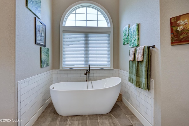 6133 Ridgeview Ct, Joplin, MO 64804 - bathroom with tile walls, a soaking tub, and wainscoting