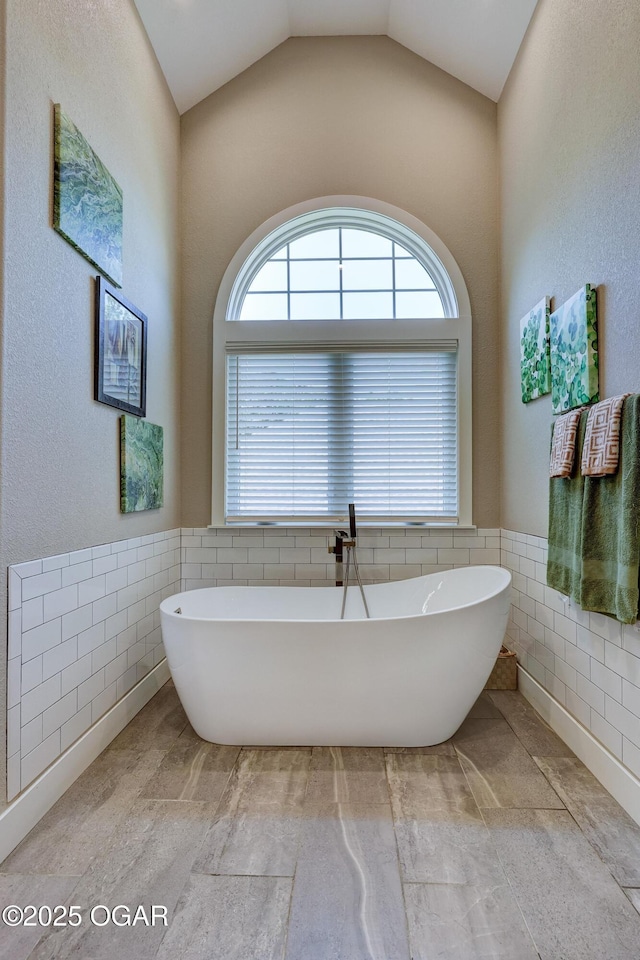 6133 Ridgeview Ct, Joplin, MO 64804 - bathroom with tile walls, a freestanding bath, and wainscoting