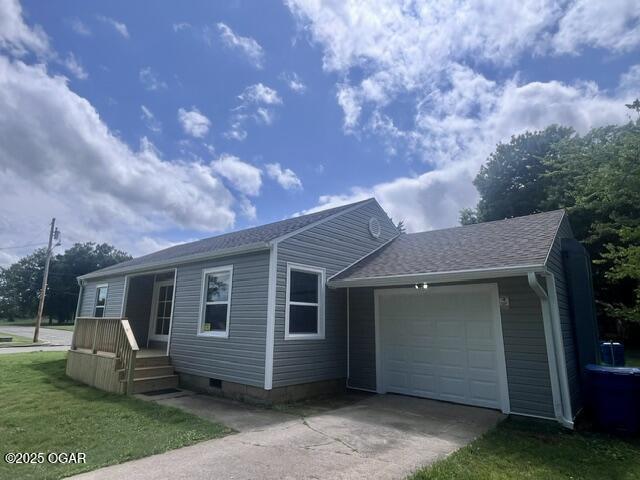 828 S Porter Ave, Joplin, MO 64801 - view of front of home with concrete driveway, a garage, a front yard, and roof with shingles