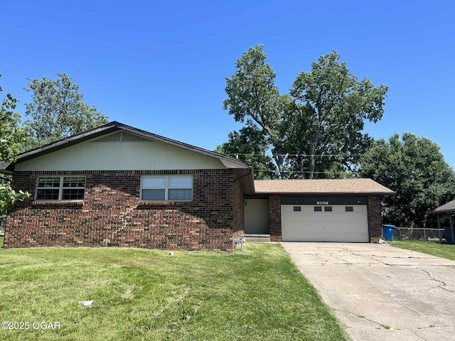 1617 Massachusetts Ave, Joplin, MO 64804 - view of front of home with an attached garage, brick siding, concrete driveway, and a front lawn