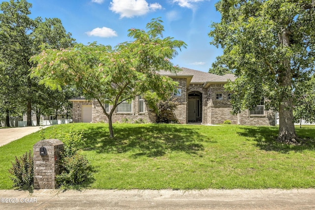 305 Dogwood Trails Loop, Carl Junction, MO 64834 - obstructed view of property with a front lawn, brick siding, and an attached garage