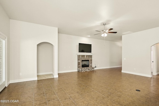 305 Dogwood Trails Loop, Carl Junction, MO 64834 - unfurnished living room featuring arched walkways, a ceiling fan, a fireplace, and tile patterned floors