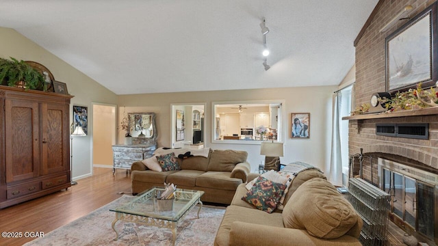 21974 S 1825th Rd, Milo, MO 64767 - living area featuring vaulted ceiling, wood finished floors, and a brick fireplace