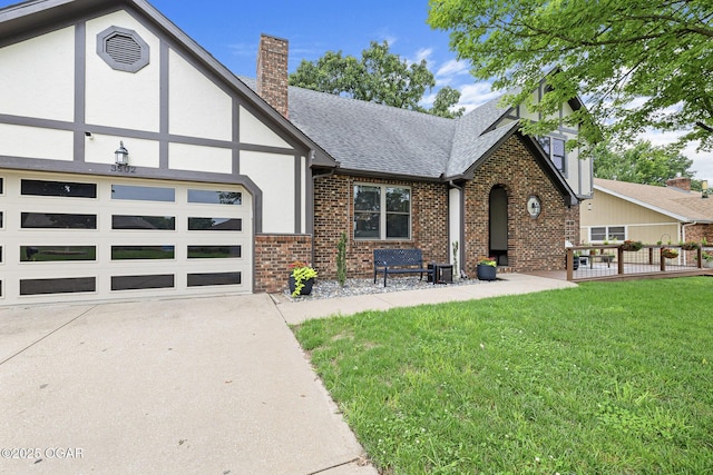 3502 Hackberry Ln, Joplin, MO 64801 - tudor house featuring a shingled roof, a chimney, brick siding, a front lawn, and concrete driveway