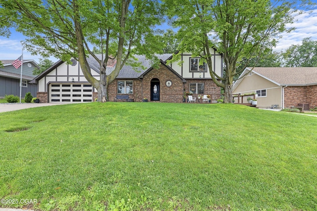 3502 Hackberry Ln, Joplin, MO 64801 - english style home featuring an attached garage, a front lawn, brick siding, and concrete driveway