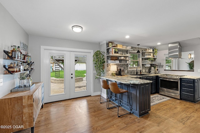 3502 Hackberry Ln, Joplin, MO 64801 - kitchen with stainless steel range with gas cooktop, exhaust hood, open shelves, a peninsula, and light wood-style flooring