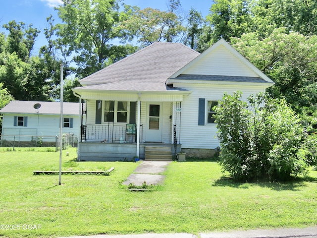 722 E Budlong St, Carthage, MO 64836 - view of front of property with covered porch, a front yard, and a shingled roof