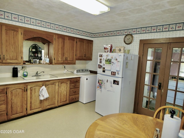 722 E Budlong St, Carthage, MO 64836 - kitchen with freestanding refrigerator, washer / clothes dryer, wallpapered walls, brown cabinets, and light countertops