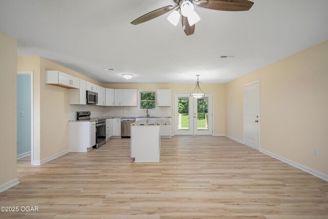 303 Water St, Exeter, MO 65647 - kitchen featuring stainless steel appliances, white cabinets, light wood finished floors, and a ceiling fan