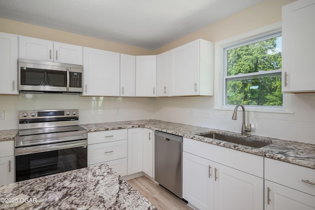 303 Water St, Exeter, MO 65647 - kitchen featuring appliances with stainless steel finishes, tasteful backsplash, light stone counters, and a textured ceiling