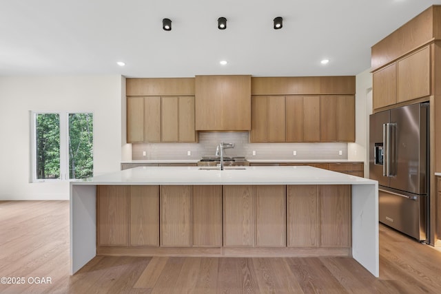 5077 Eagle Valley Dr, Joplin, MO 64804 - kitchen featuring high quality fridge, light countertops, light wood-type flooring, decorative backsplash, and recessed lighting
