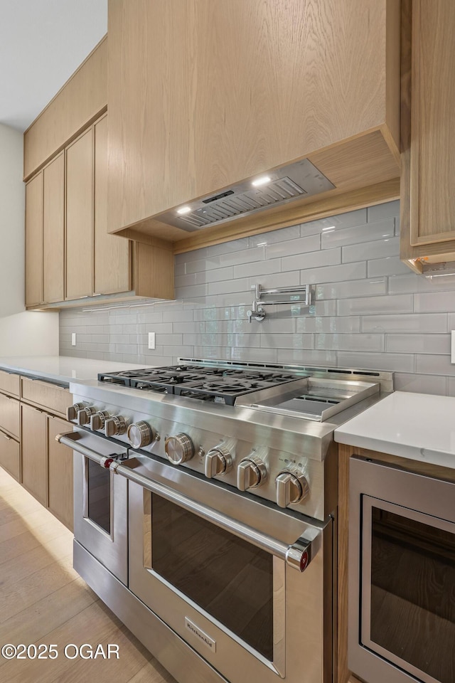 5077 Eagle Valley Dr, Joplin, MO 64804 - kitchen with appliances with stainless steel finishes, light brown cabinets, backsplash, light countertops, and light wood-style flooring
