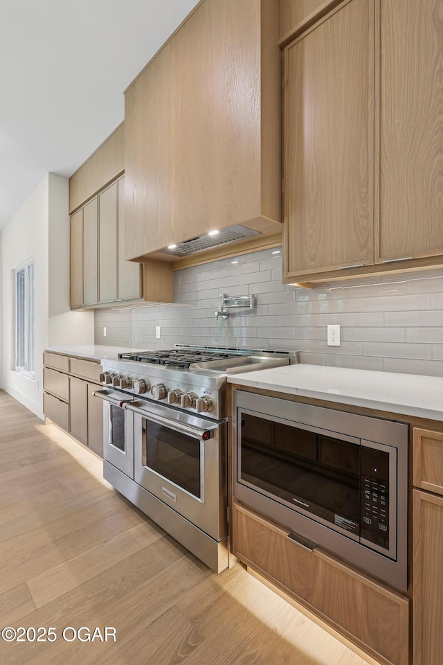 5077 Eagle Valley Dr, Joplin, MO 64804 - kitchen featuring appliances with stainless steel finishes, light countertops, backsplash, and light wood-style floors