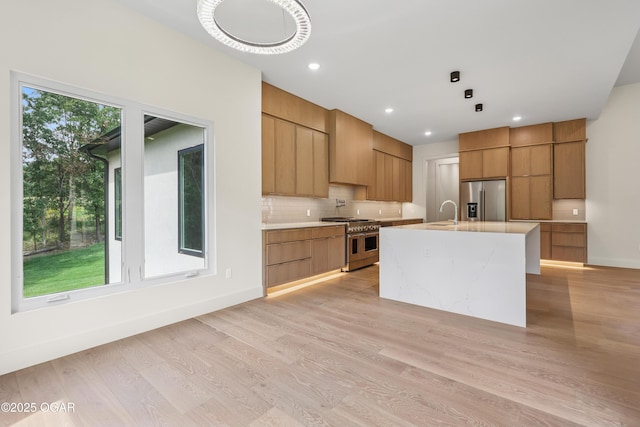 5077 Eagle Valley Dr, Joplin, MO 64804 - kitchen featuring stainless steel appliances, modern cabinets, light countertops, tasteful backsplash, and light wood-type flooring