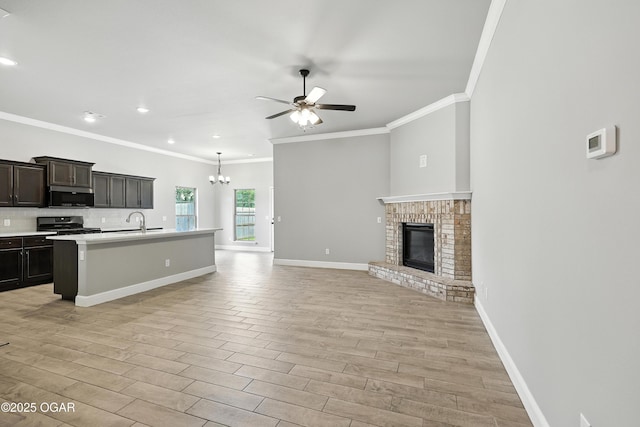 2102 S Greystone Sq, Oronogo, MO 64855 - kitchen with stainless steel microwave, ornamental molding, open floor plan, a ceiling fan, and a chandelier