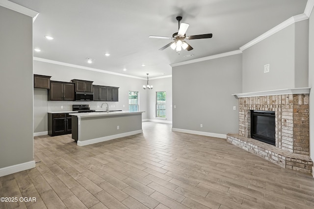 2102 S Greystone Sq, Oronogo, MO 64855 - kitchen with stainless steel microwave, stove, open floor plan, ceiling fan, and ornamental molding