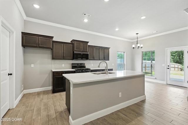 2102 S Greystone Sq, Oronogo, MO 64855 - kitchen featuring range with gas stovetop, stainless steel microwave, light wood-style flooring, a chandelier, and ornamental molding