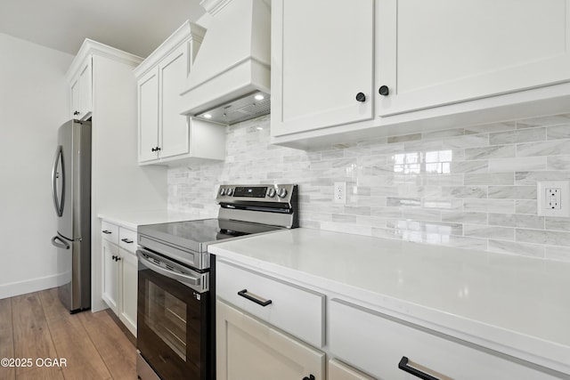 4308 Par Ln, Joplin, MO 64804 - kitchen featuring appliances with stainless steel finishes, custom exhaust hood, light countertops, white cabinetry, and light wood-style floors