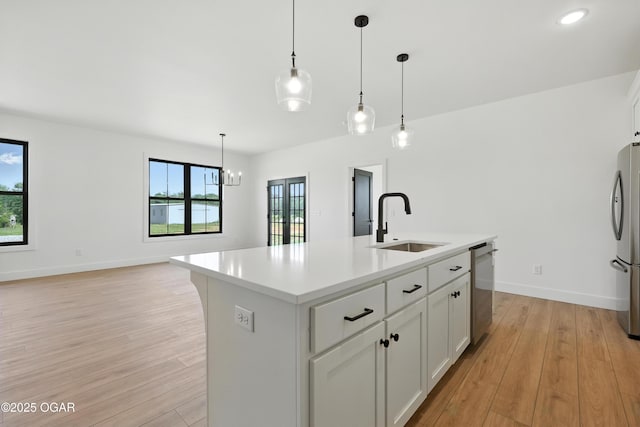 4308 Par Ln, Joplin, MO 64804 - kitchen with light wood-style flooring, appliances with stainless steel finishes, light countertops, hanging light fixtures, and white cabinetry