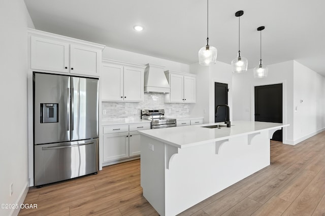 4308 Par Ln, Joplin, MO 64804 - kitchen featuring appliances with stainless steel finishes, custom exhaust hood, a kitchen island with sink, white cabinetry, and light countertops