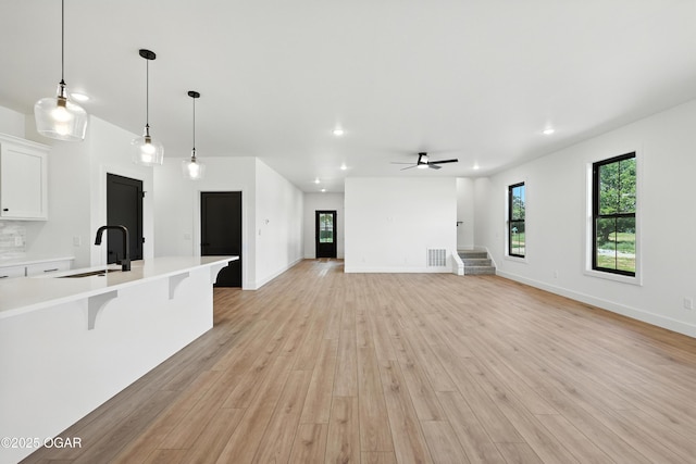 4308 Par Ln, Joplin, MO 64804 - unfurnished living room featuring light wood finished floors, recessed lighting, ceiling fan, and stairs