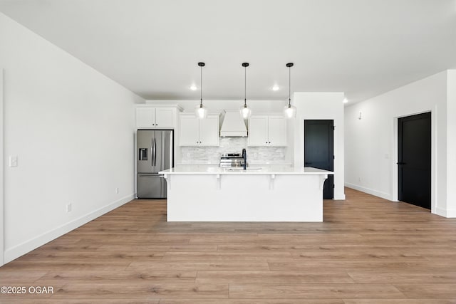 4308 Par Ln, Joplin, MO 64804 - kitchen featuring appliances with stainless steel finishes, premium range hood, recessed lighting, a kitchen island with sink, and light countertops