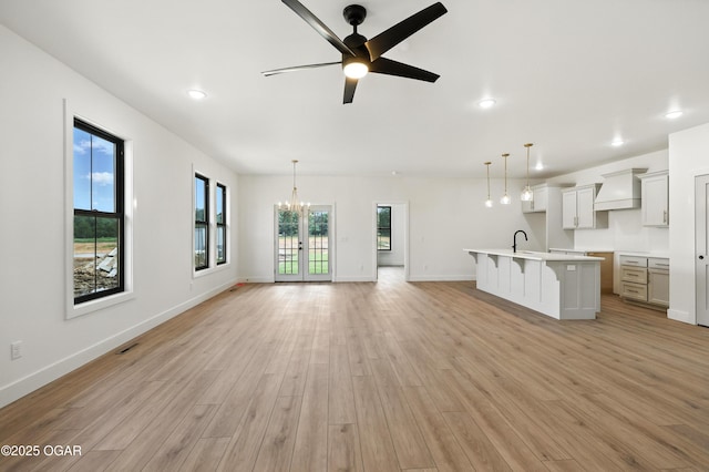 4402 Par Ln, Joplin, MO 64804 - unfurnished living room with light wood-type flooring, a chandelier, a ceiling fan, and recessed lighting