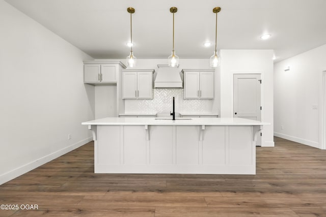 4402 Par Ln, Joplin, MO 64804 - kitchen with premium range hood, light countertops, a center island with sink, tasteful backsplash, and a kitchen bar