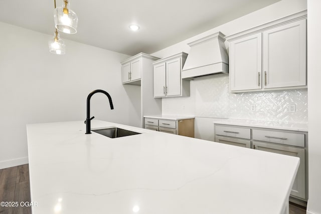 4402 Par Ln, Joplin, MO 64804 - kitchen featuring premium range hood, dark wood finished floors, a kitchen island with sink, light stone counters, and backsplash