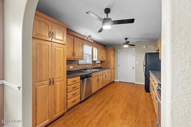 2329 S Willard Ave, Joplin, MO 64804 - kitchen featuring stainless steel dishwasher, dark countertops, a ceiling fan, freestanding refrigerator, and light wood finished floors