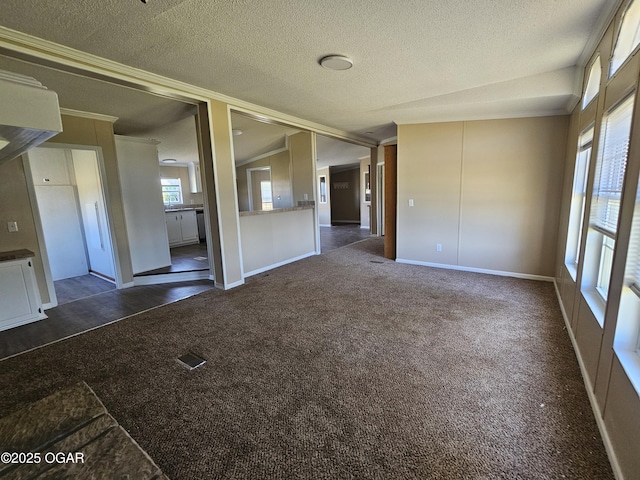 205 College St, Stark City, MO 64866 - spare room featuring a textured ceiling, dark colored carpet, vaulted ceiling, and ornamental molding